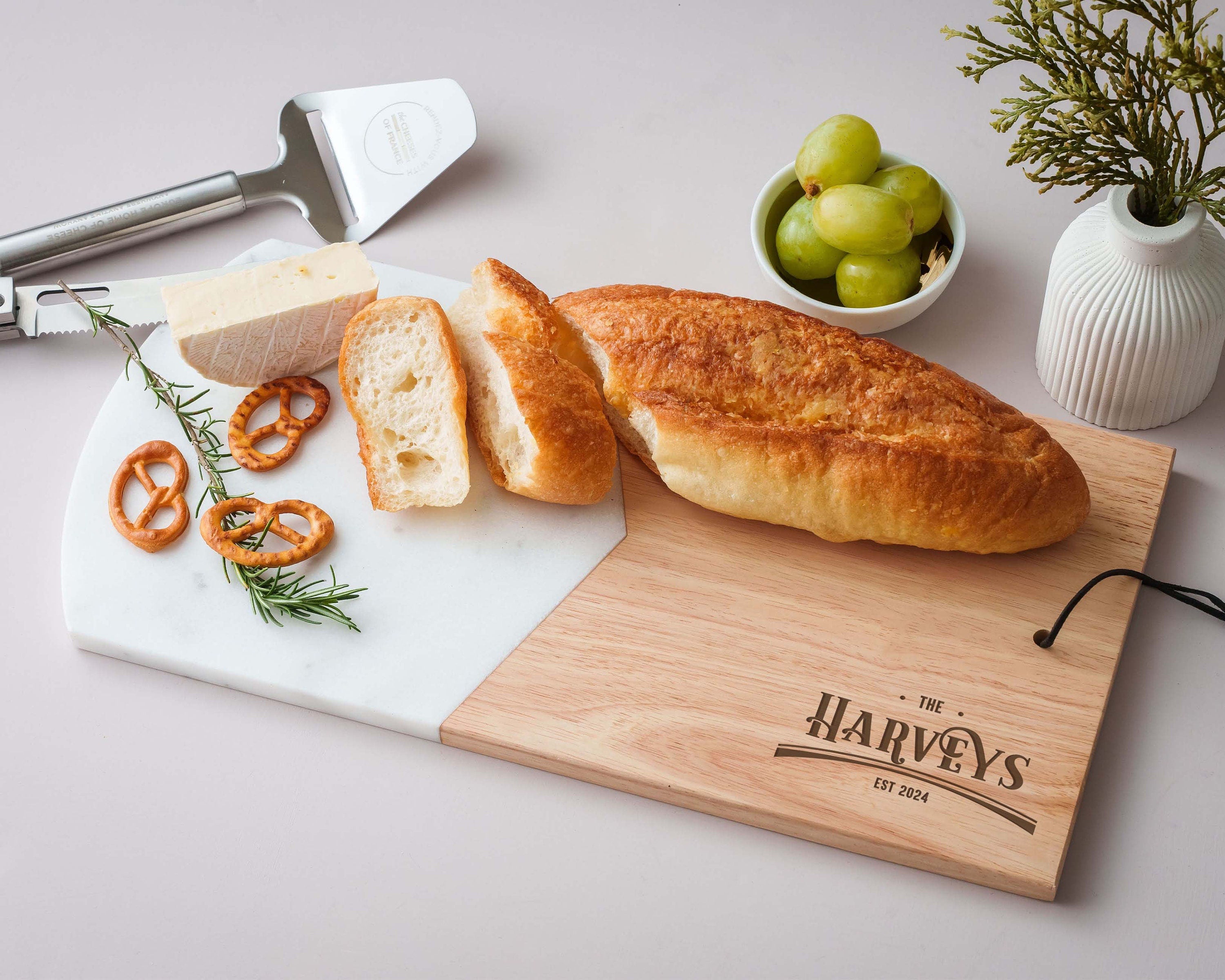 a cutting board with bread, pretzels, and olives on it