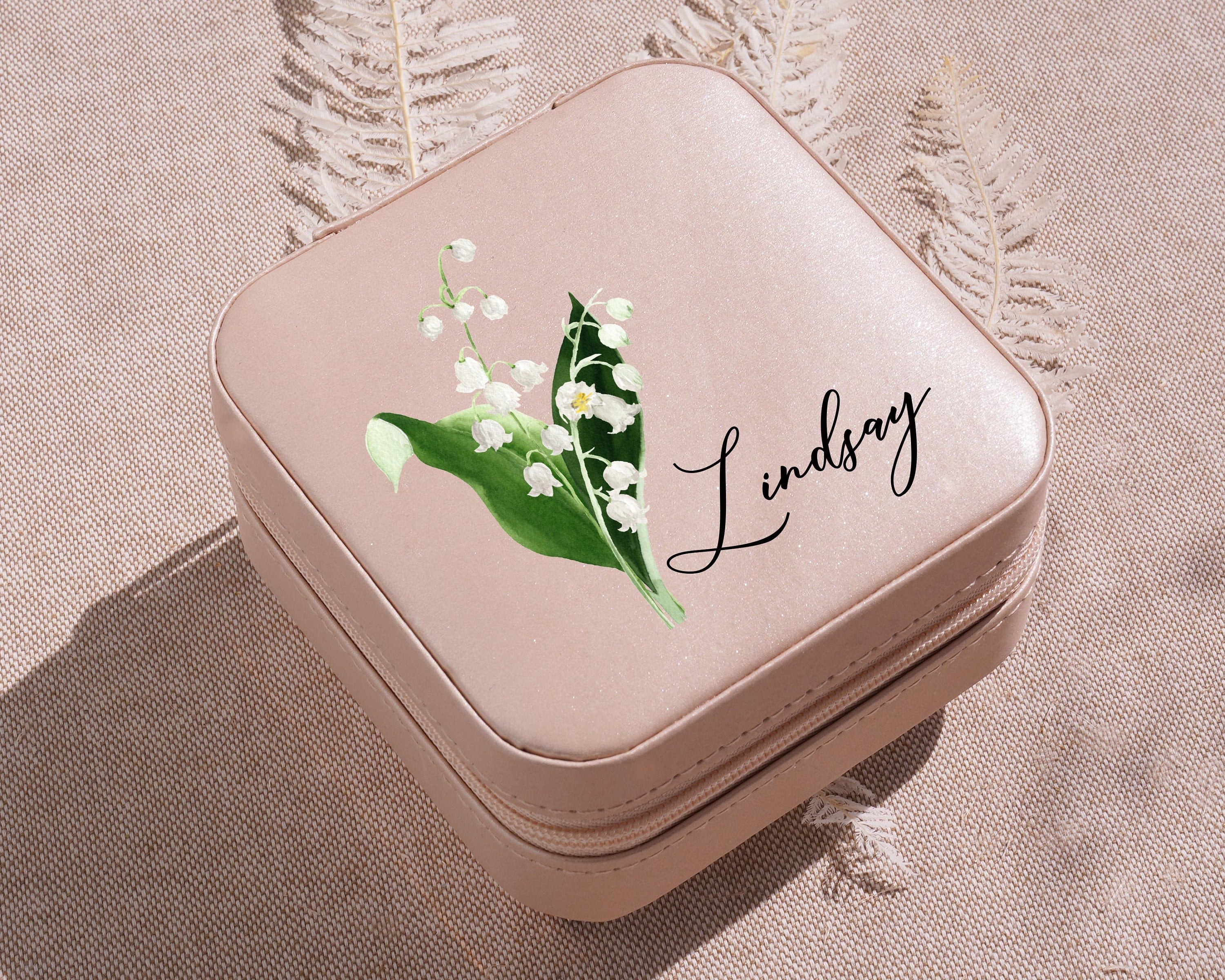 a small pink box with a picture of a lily of the valley on it