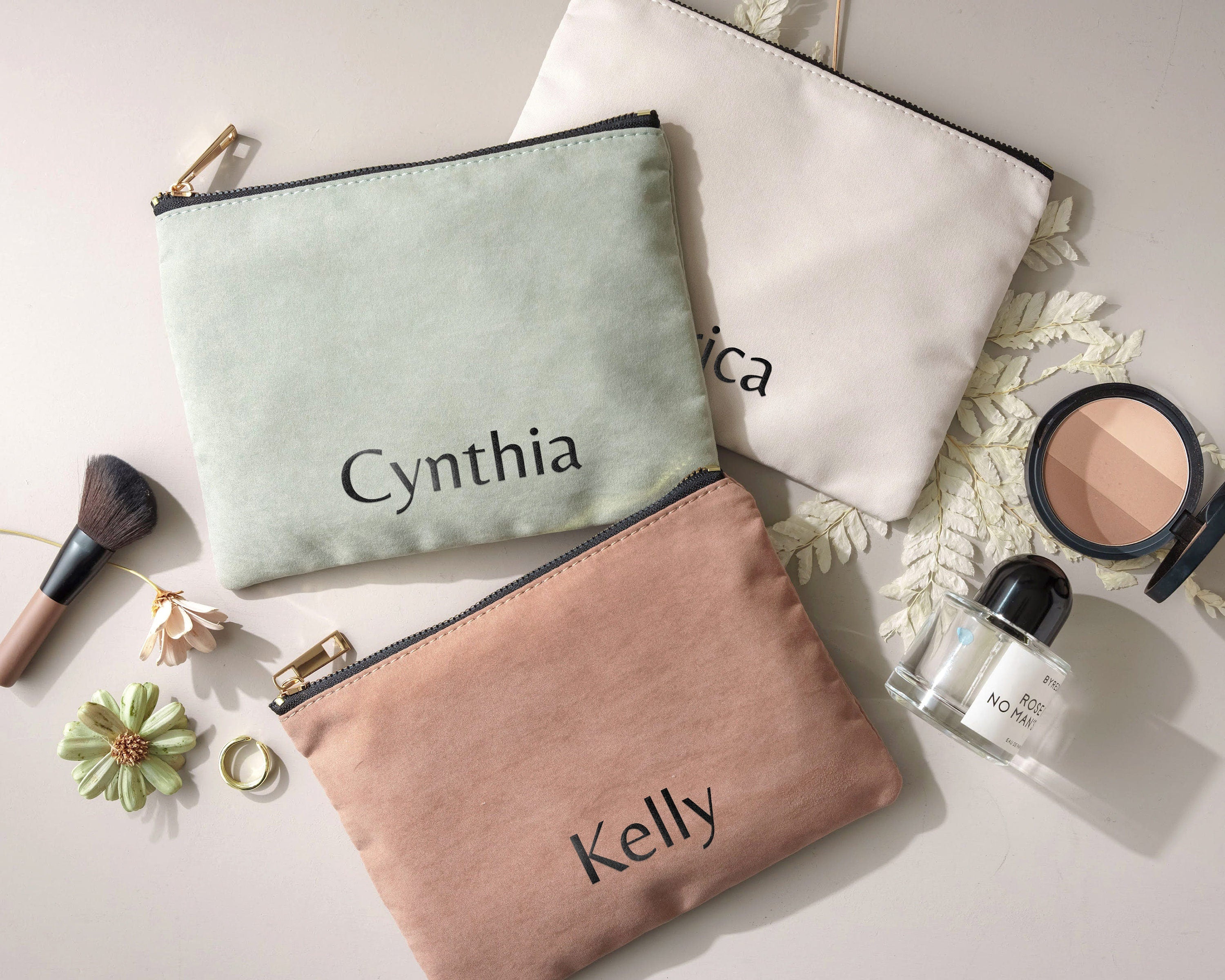 a cosmetic bag with a name on it next to other items