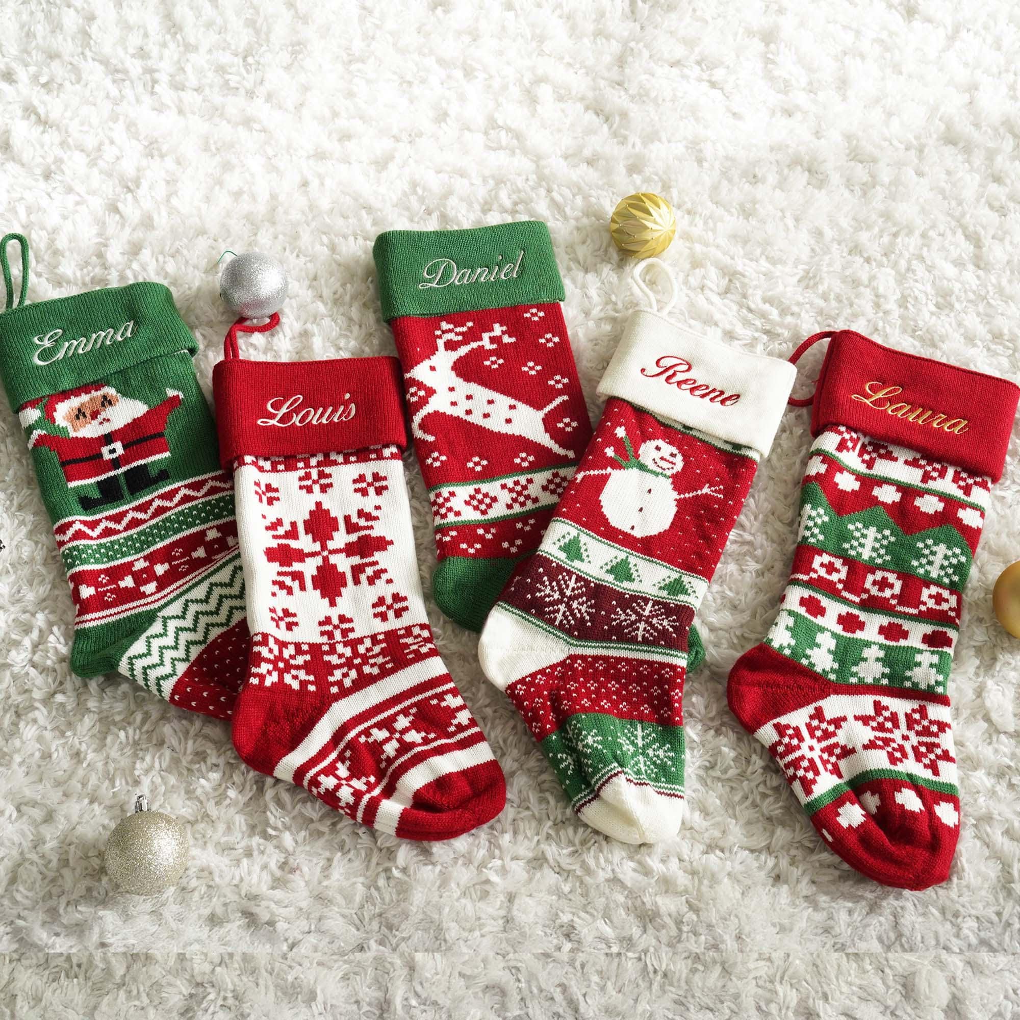 a group of christmas stockings sitting on top of a white carpet