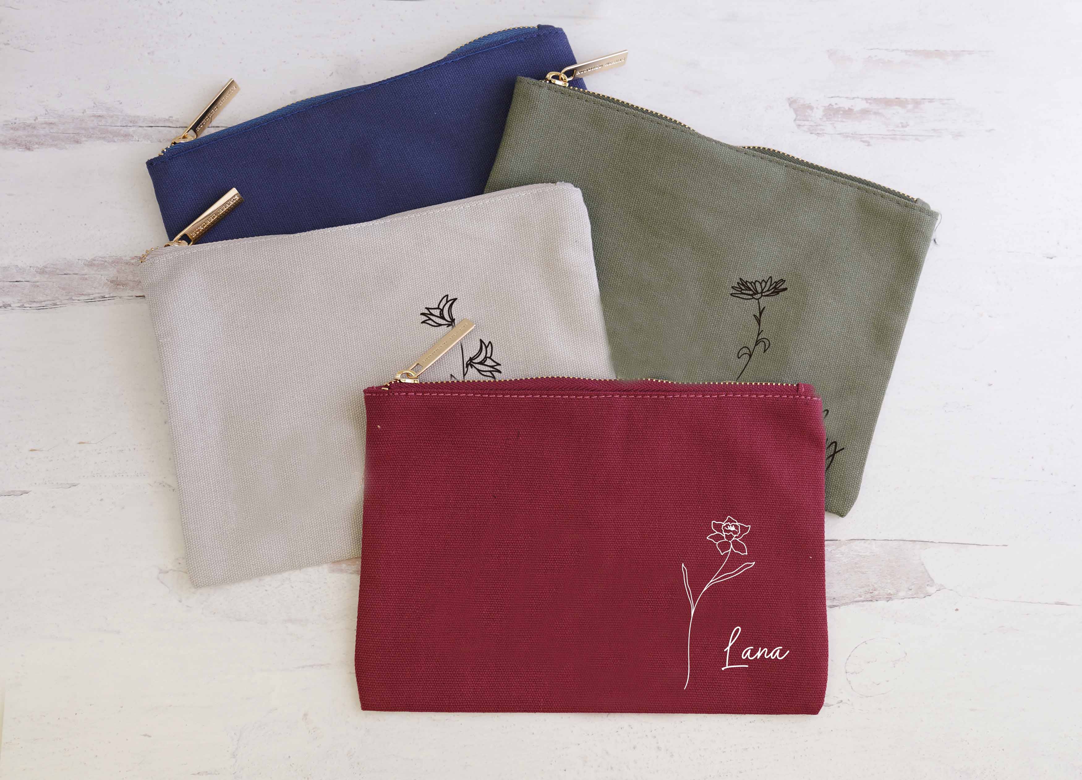 Cranberry, Grey, Sage and midnight blue Personalized Cosmetic Bags with birth flower image and name.